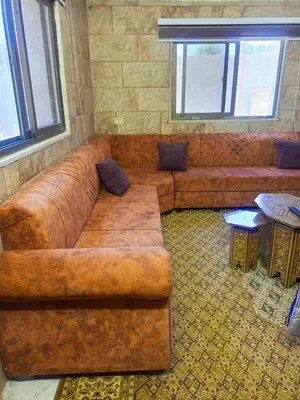 a large brown leather couch in a living room at الاردن جرش سوف in Jerash