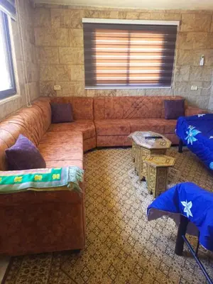 a living room with a large couch and a table at الاردن جرش سوف in Jerash