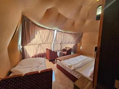 a small room with two beds and a window at Echo of the Sands in Wadi Rum
