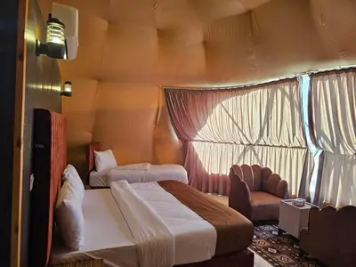 a bedroom with a bed and a chair in a room at Echo of the Sands in Wadi Rum
