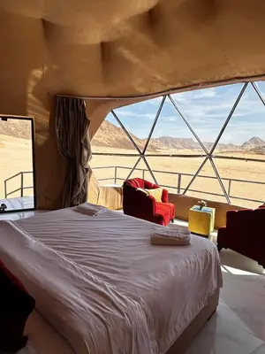 a bed in a tent with a view of the desert at Desert Star Camp in Disah