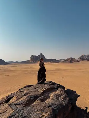 a couple standing on a rock in the desert at Desert Star Camp in Disah