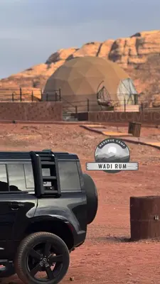 a truck parked in front of a wadi rum sign at WADI RUM RESERVE BUBBlE CAMP in Wadi Rum