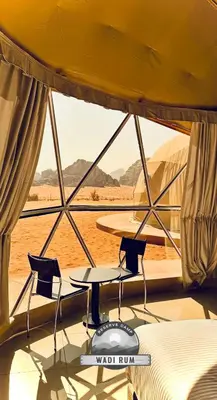 a room with two chairs and a table and a window at WADI RUM RESERVE BUBBlE CAMP in Wadi Rum