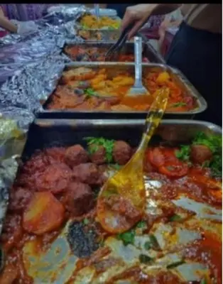 a buffet with many trays of food with a spoon at Ram Camp Desert in Wadi Rum