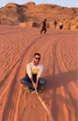 a man is pulling a rope in the desert at Ram Camp Desert in Wadi Rum