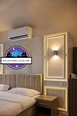 a bedroom with a bed and a light on a wall at RUM LARA BUBBLES lUXURY CAMP in Wadi Rum
