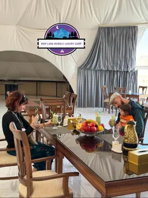 a group of people sitting at a table in a tent at RUM LARA BUBBLES lUXURY CAMP in Wadi Rum