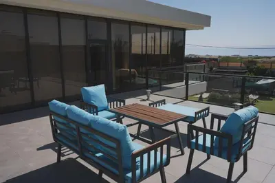 a patio with a table and chairs on a balcony at Atlantis The Palm Villa in Al Rama