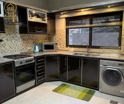 a kitchen with a sink and a dishwasher at Ajaza Real Estate in Amman