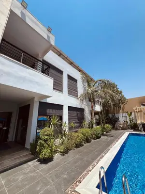 a house with a swimming pool next to a building at Mirabella Villa in Al Rama