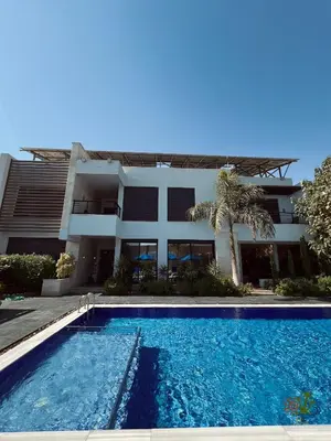 a house with a swimming pool in front of a building at Mirabella Villa in Al Rama