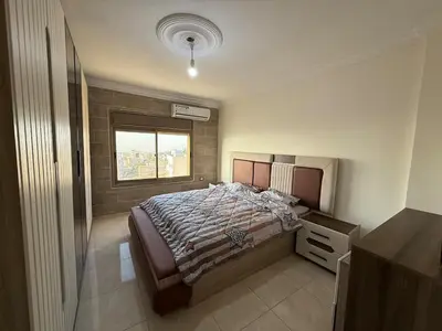 a bedroom with a large bed and a window at شقة للإيجار في عجلون in Ajloun