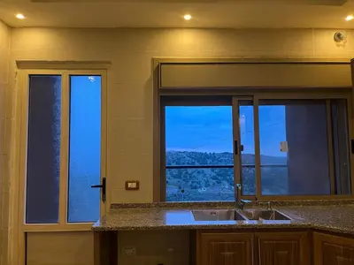 a kitchen with a sink and a window with a view at شقة للإيجار في عجلون in Ajloun
