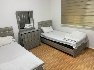 two twin beds in a room with a mirror at jawharet el ordon in Amman