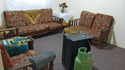 a living room with a couch and two chairs and a table at عجلون اشتفينا in Ajloun