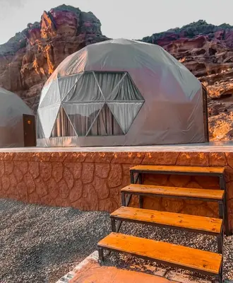a dome tent with a wooden bench in front of it at Solar Soul Camp - Wadi Rum Desert Experience & Stargazing in Wadi Rum
