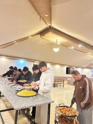 a group of people standing around a table with food at LONAR LORE lUXURY CAMP in Disah