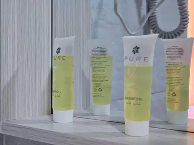 a group of four bottles of moisturizing moisturizers on a shelf at LONAR LORE lUXURY CAMP in Disah