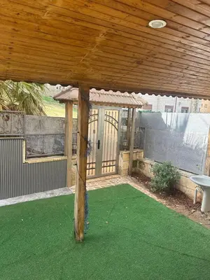 a covered patio with green grass and a wooden ceiling at Rasheed pearl in Amman