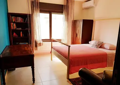 a bedroom with a bed and a chair and a window at Luxury 3 bedrooms flat with great view of Amman in Amman
