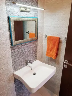 a bathroom with a white sink and a mirror at Luxury 3 bedrooms flat with great view of Amman in Amman