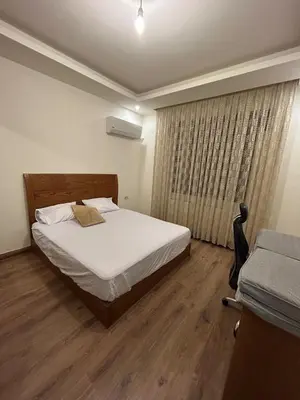 a bedroom with a white bed and a window at 3BR Escape with Outdoor Scenic Views in Amman