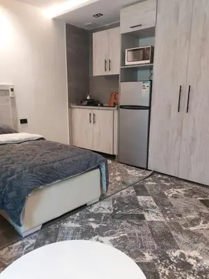a bedroom with a bed and a refrigerator and cabinets at رياحين الخلود in Amman