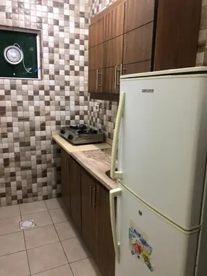 a kitchen with a white refrigerator and brown cabinets at رياحين الخلود in Amman