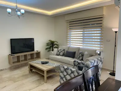 a living room with a couch and a flat screen tv at 3 bedroom flat, 3 bathrooms, 7th circle, Amman in Amman
