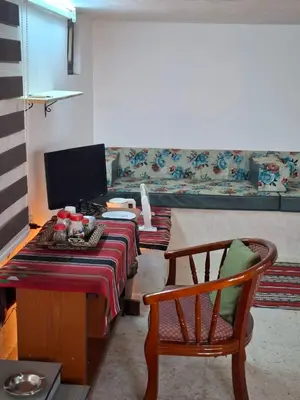 a living room with a couch and a table and a chair at Mountain Pad Overlooking Jerash - HQ Budget stay in Jerash