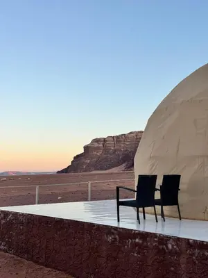 two chairs sitting in front of a tent in the desert at Dawn Rum Luxury Camp in Wadi Rum
