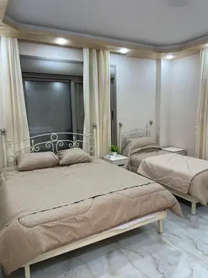 a bedroom with two beds and a mirror at Royal airport hotel in Amman