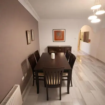 a dining room with a black table and chairs at Mecca Street Cozy Apartment in Amman