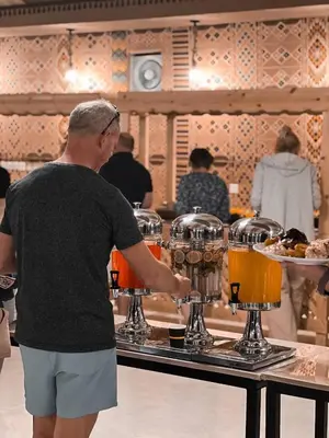 a man standing in front of a bar preparing drinks at Victoria rum Luxury camp in Disah