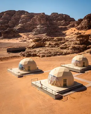 three tents in a desert with rocks in the background at Victoria rum Luxury camp in Disah