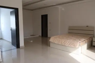 a bedroom with a bed in the middle of a room at شقق الاستقلال in Amman