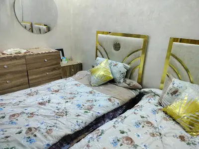a bedroom with two beds and a dresser and a mirror at شقق مفروشه فاخره2 in Aqaba