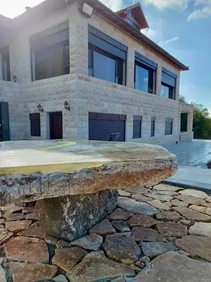 a stone bench in front of a house at Bait Ajloun in Khirbat Shīn