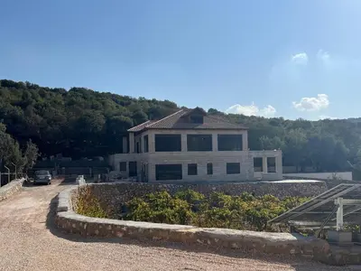 a large white house on top of a hill at Bait Ajloun in Khirbat Shīn