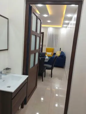 a living room with a blue couch and a table at Bait Ajloun بيت عجلون 2 in Khirbat Shīn