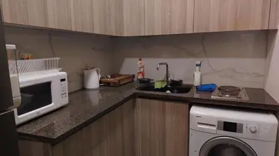 a kitchen with a microwave and a washing machine at home 7 in Amman