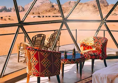 a room with chairs and a table with a view of the desert at Teraa rum luxury camp in Wadi Rum