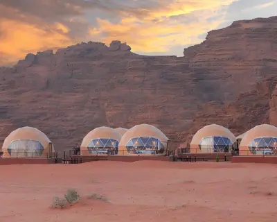a group of domes in the desert with a mountain at Teraa rum luxury camp in Wadi Rum