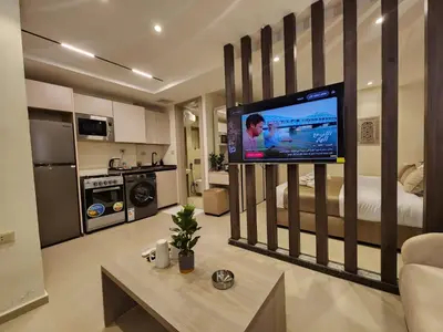 a living room with a large television in a bedroom at ذا سهل ستيز in Amman