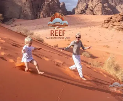 a woman and a child walking in the desert at Reef Rum Luxury Camp in Disah