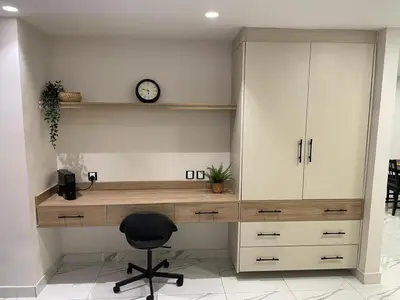 a desk with a chair and a clock on a wall at Damac Towers TC1-517 in Amman