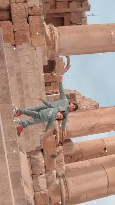 a man climbing up the side of a brick building at Flowers in Jerash
