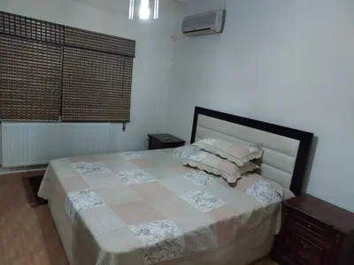 a bedroom with a bed with pillows and a window at استديو للتأجير السنوي او البيع in Amman