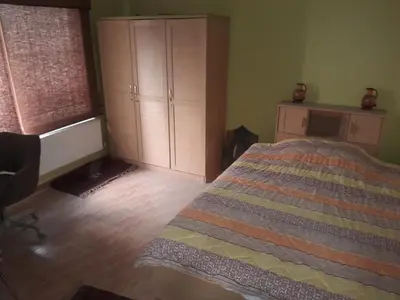 a bedroom with a bed and a dresser and a window at استديو للتأجير السنوي او البيع in Amman